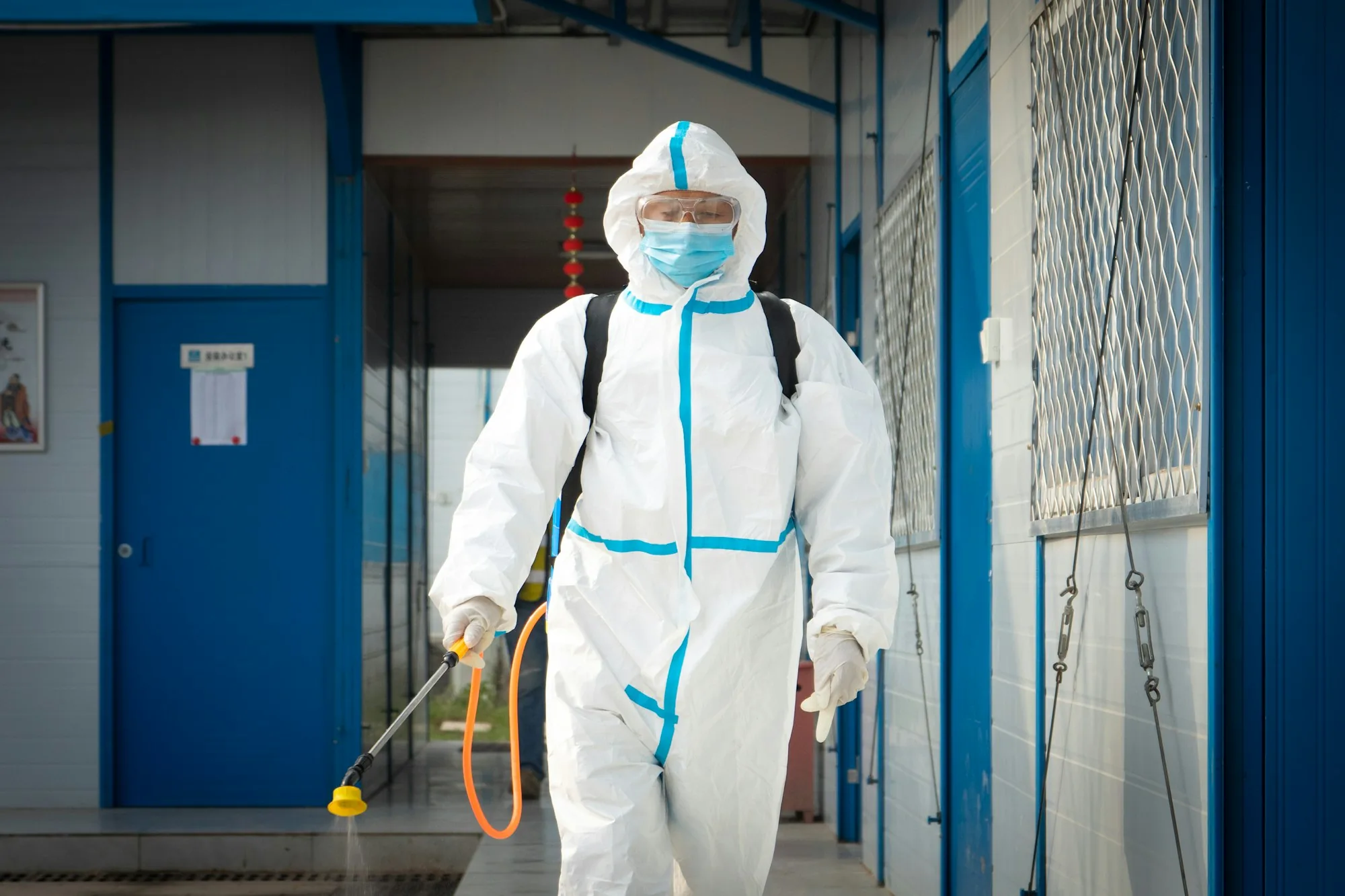 Technicien Hygiène Habitat en tenue de protection en train de traiter un local contre les nuisibles